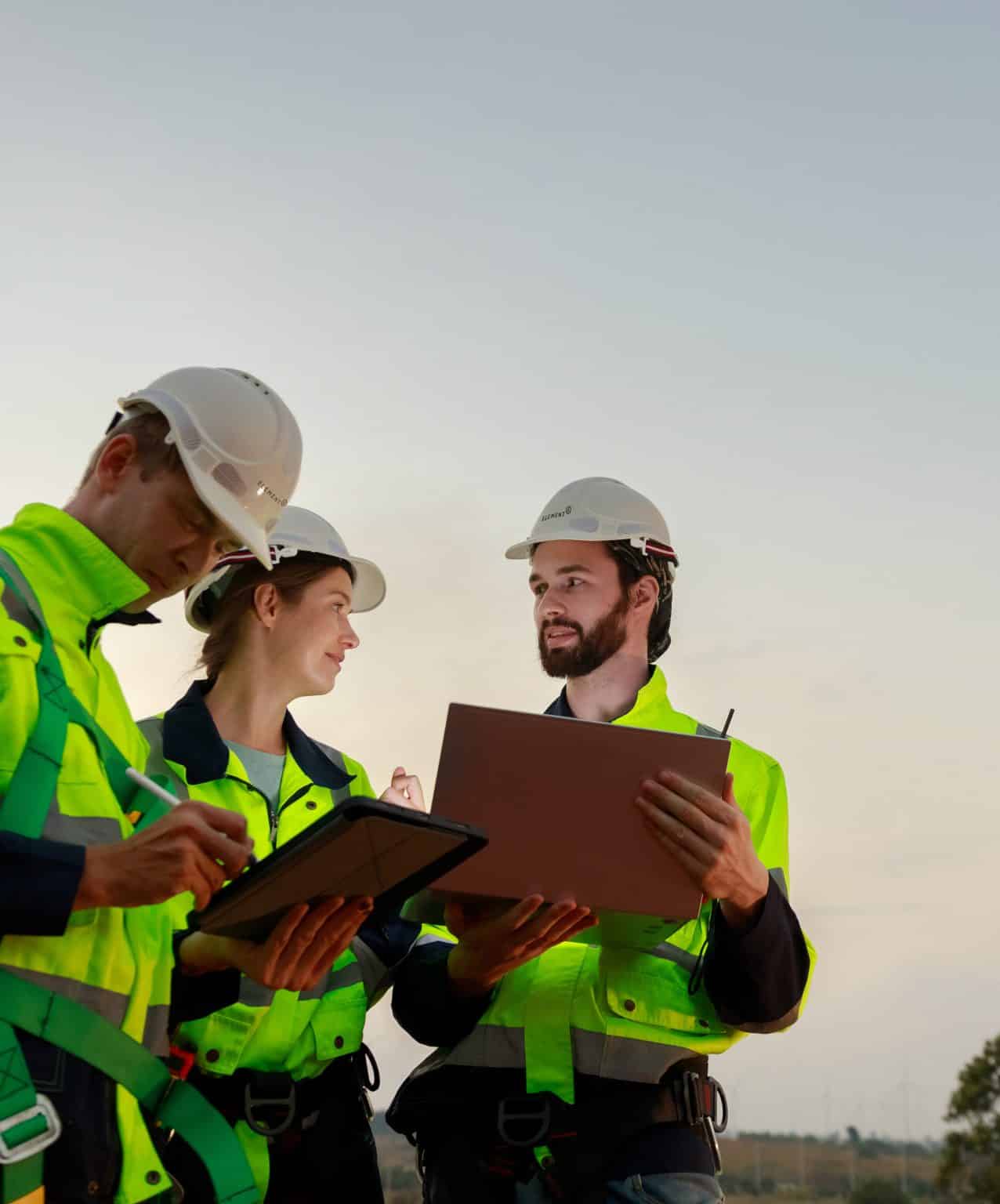Engineer wearing safety uniform using tablet discussed plan about renewable energy at station energy power wind turbine. technology protect environment reduce global warming problems.
